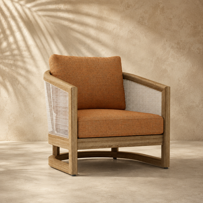 Brown armchair with wooden frame and woven backrest against a textured beige wall.