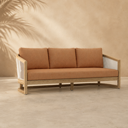 Brown sofa with wooden frame against a beige wall