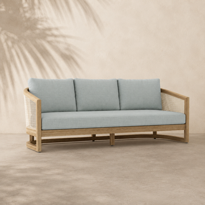 Light blue cushioned sofa with wooden frame on a beige background