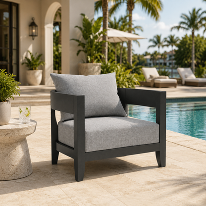 Outdoor chair with gray cushions by a poolside in a tropical setting