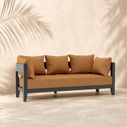 Sofa with brown cushions against a beige wall