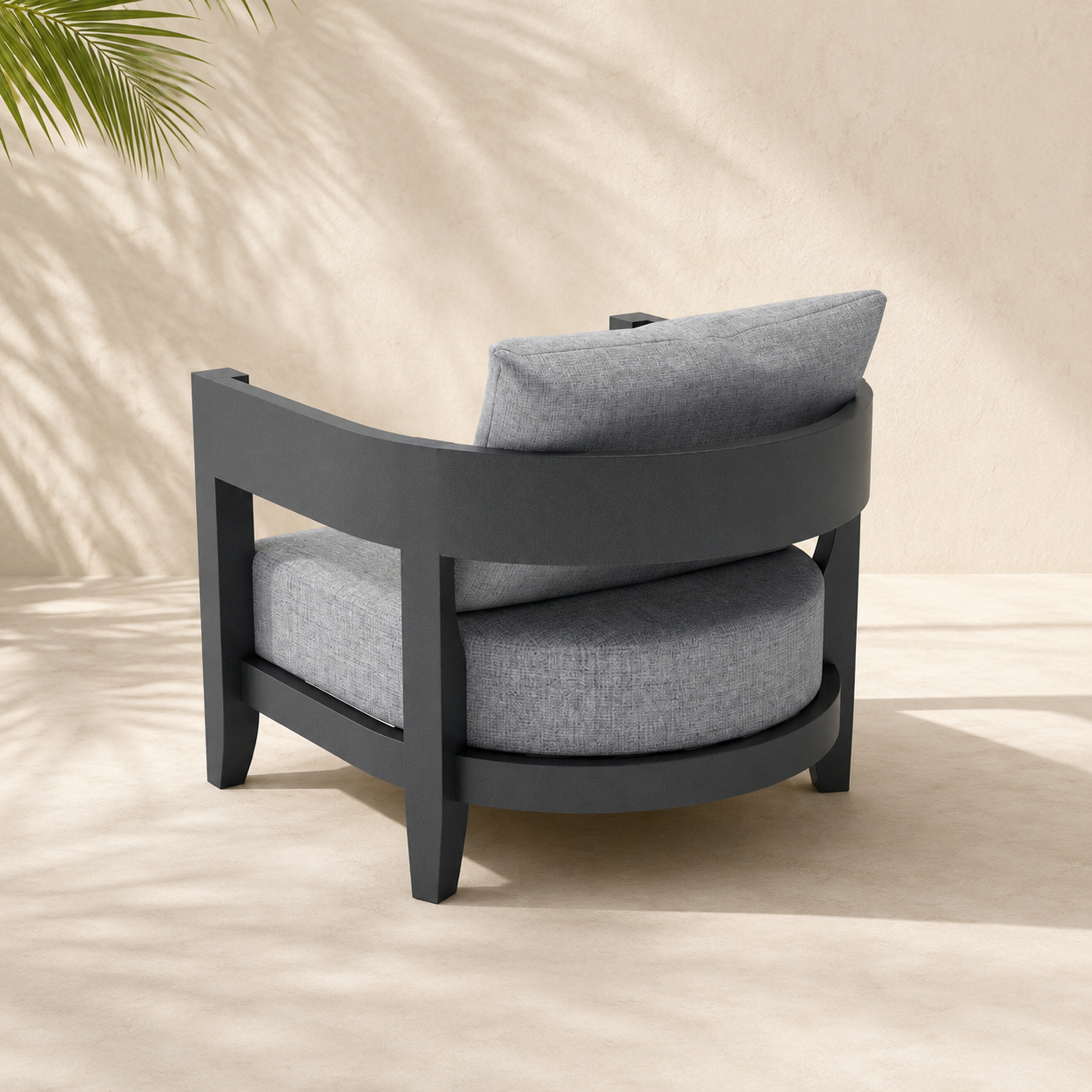 Gray cushioned chair with a plant in the corner on a beige background