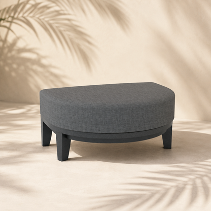 Gray ottoman on a beige background with palm leaf shadows