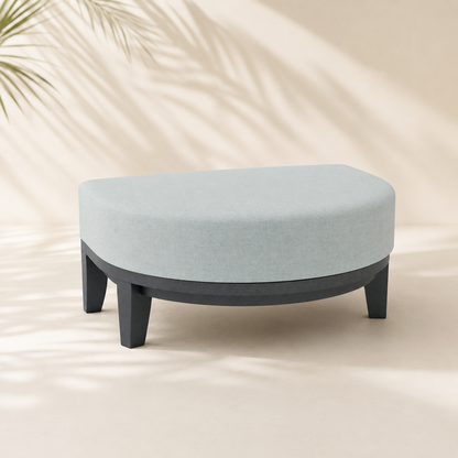Round ottoman with light gray cushion on a beige background