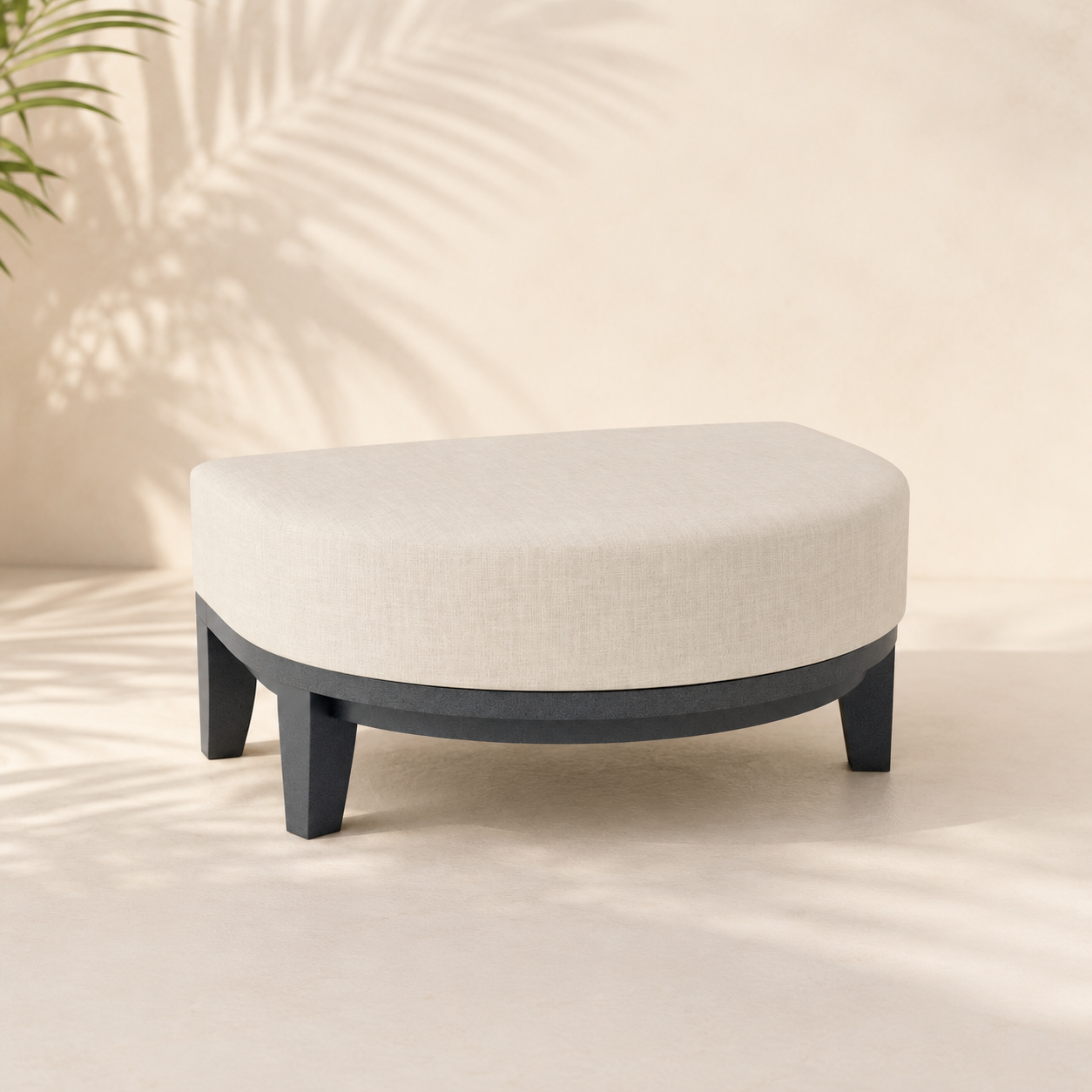 Round ottoman with white cushion and black legs on a neutral background