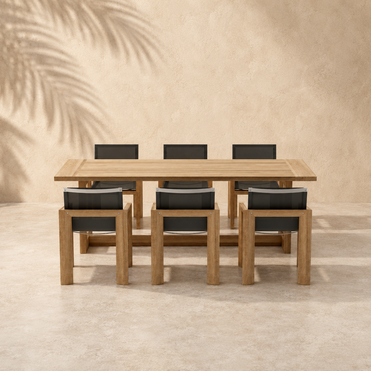 Wooden dining table with six chairs against a beige wall with palm leaf shadows.